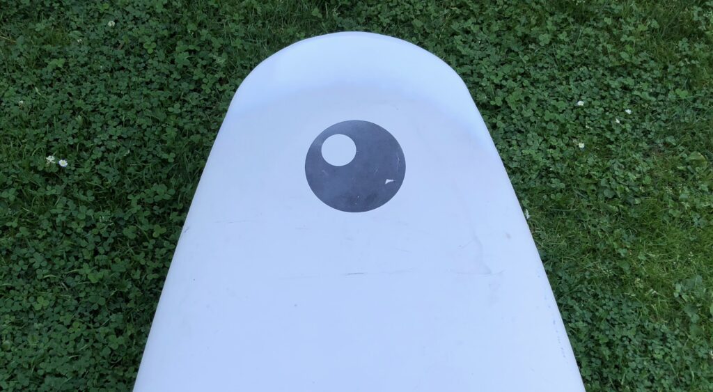 The repaired nose of the surfboard is painted.